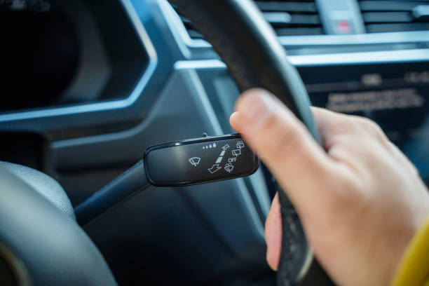 istock Man's hand on the car window washer switch 1693697864