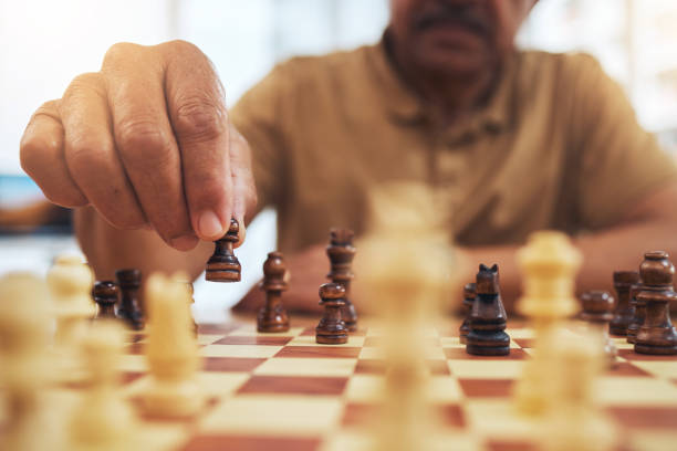 istock Man, chess board game and hands on pawn for fun strategy, hobby and decision in challenge. Closeup, chessboard or player moving piece for winning contest, competition or learning tabletop brain games 1693714846
