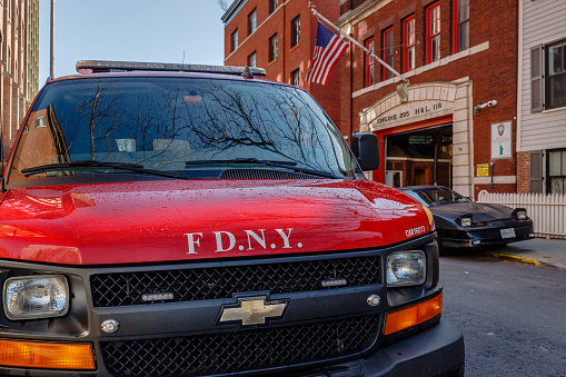 Brooklyn, New York, USA - February 11, 2023: FDYN fire engines in front of Engine 205 H&L 118 fire station garage door in Brooklyn next to Manhattan on a winter day