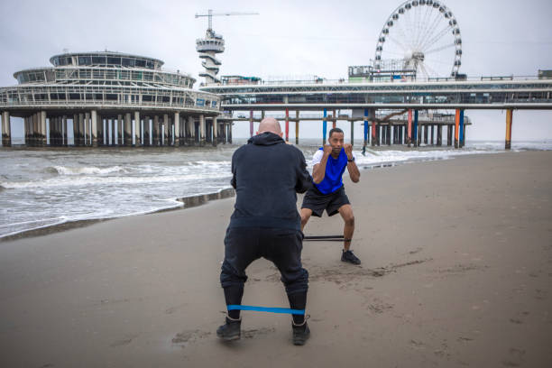 istock A black male and personal trainer working out on the beach 1693726312