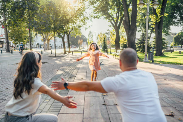 istock Little daughter running to parents 1693728188