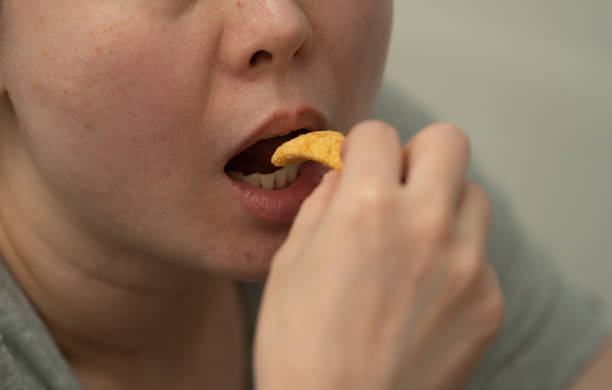istock close up of mouth eating snack 1693728202