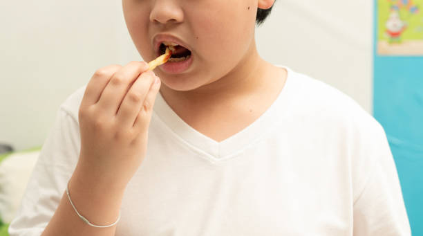 istock kid eat french fries in room 1693729366