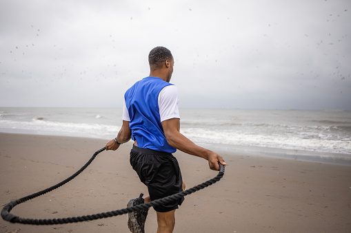 A handsome black male working out on the beach to get ready for the dating world