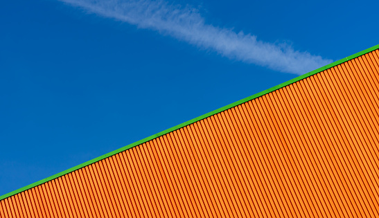Germany, Berlin, September 01, 2023 - Orange facade of warehouse building against sky, Berlin Marzahn