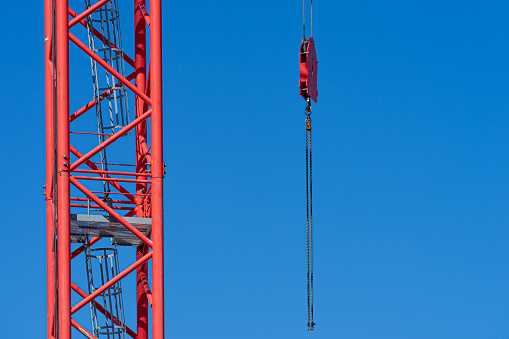 Germany, Berlin, September 06, 2023 - Close up of red crane and hook against clear blue sky, Berlin Central