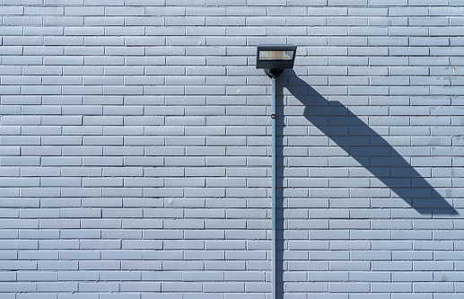 Germany, Berlin, September 19, 2023 - Lamp on brick wall and drop shadow, Berlin Zehlendorf