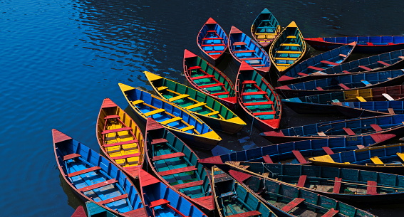 Colorful wooden boats moored at Phewa (or Fewa) lake of Pokhara, the second most populous city of Nepal, some 200 km west of Kathmandu, Nepal