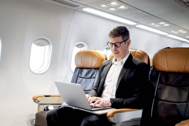 istock Busy businessman working on laptop computer during sitting in comfortable seat inside airplane, male passenger working in aircraft cabin during business trip, traveling with airline transportation. 1693742915