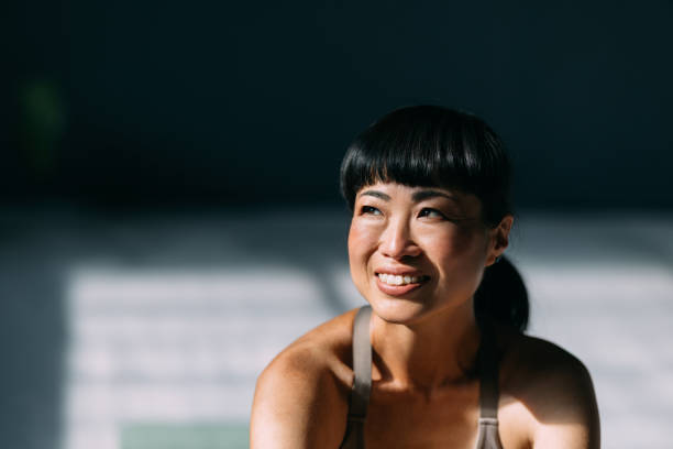 istock Happy Yoga Moment: Japanese Woman Grins on Her Mat 1693747986