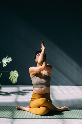 Balancing life's energies: a young Asian woman doing yoga.