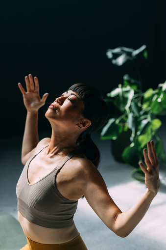 Balancing life's energies: a young Asian woman doing yoga.