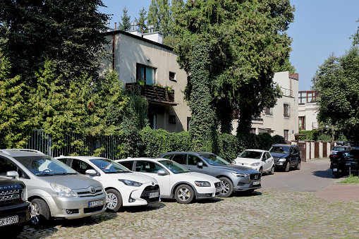 Warsaw, Poland - September 12, 2023: In the Saska Kepa housing estate, part of the Praga-Poludnie district, cars were parked among the trees next to the houses.