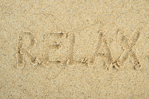 relax written on the beach