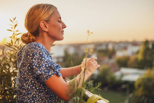 Mulher bebendo café ao pôr do sol - foto de acervo