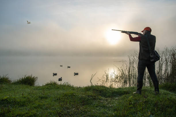 istock hunter shooting to the flying duck. hunting season. 1693767715