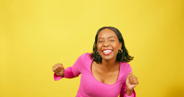 istock Happy young woman dancing, having fun, yellow studio background 1693775956