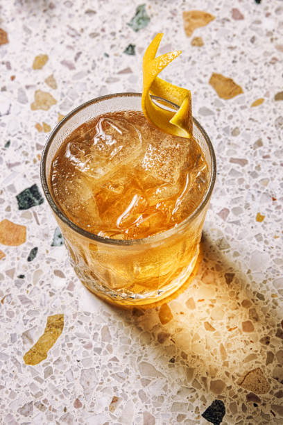 altmodischer cocktail mit orangefarbenem twist - fruit liqueur stock-fotos und bilder