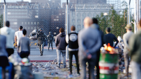 Crowd standing in front of a guarded fence dividing city and derelict area. All objects in the scene are 3D