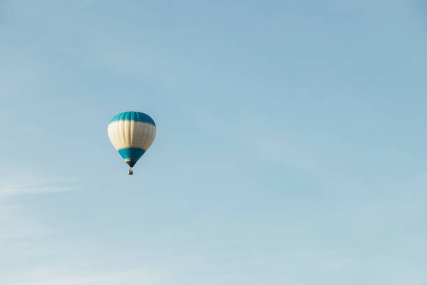 istock Hot air balloon with tourists against a blue sky. Space for text 1693808725
