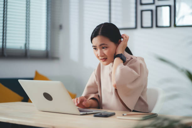istock Asian woman using laptop, thinking about project and feel confused. 1693872347
