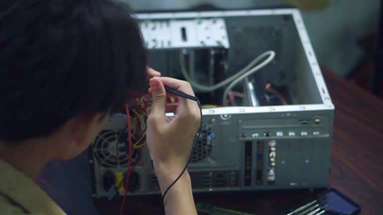 Close up hand asian students using measurements repairing electronic pc hardware in the classroom.