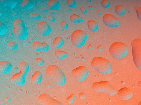 Colorful abstract of water droplets on translucent textured glass. Abstract background as a design element in aqua to red gradient.