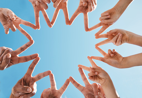 Hands, group and fingers in star for peace, collaboration and solidarity on blue sky. Family, shape and closeup in connection to network, team support and freedom of friends in cooperation to trust
