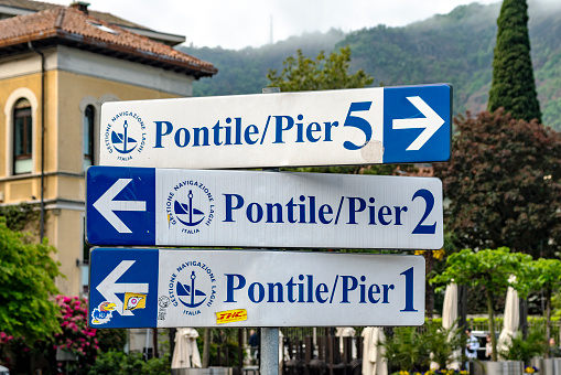 Signs for the ferry terminal departure piers at Como in Italy.