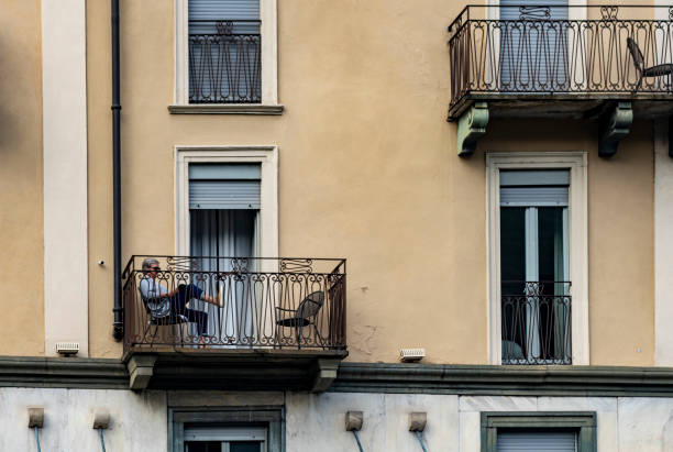 Mature woman relaxing on her balcony in Como on Lake Como.
