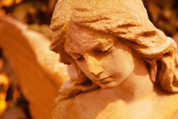 Beautiful sad angel. Retro styled image of  ancient stone statue