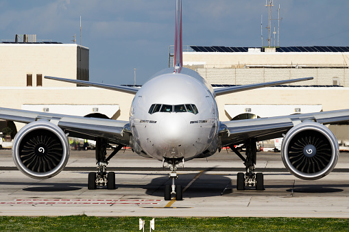 A passenger jet taxis towards an airport gate after landing.