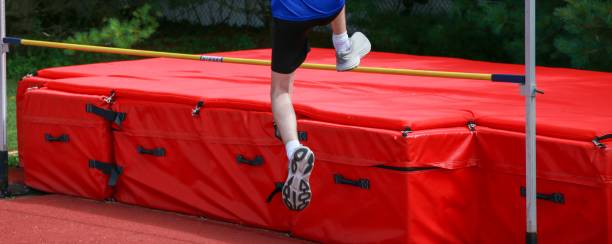 istock Young athlete jumping over a high jump bar 1694041335