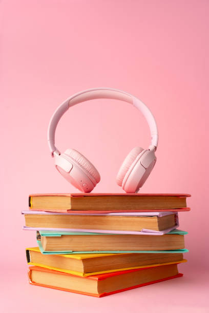 istock Pink headphones on a book on blue background 1694053688