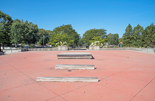 Large, pink cement plaza area of skateboard park.