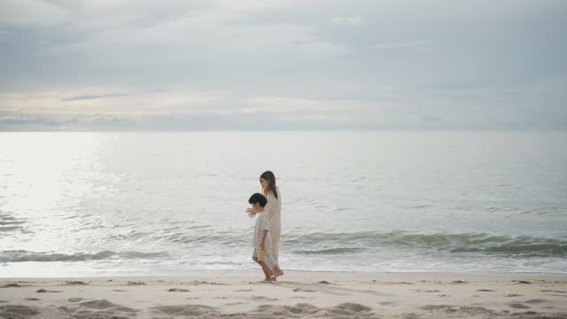 Asian young woman and her son spending the day at the beach together.