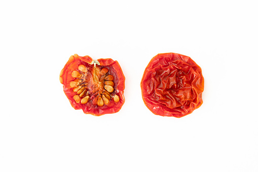 Dried cherry tomato sliced in half on white background
