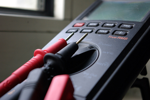 Close up photo of an electrical measurement device with black and red probes
