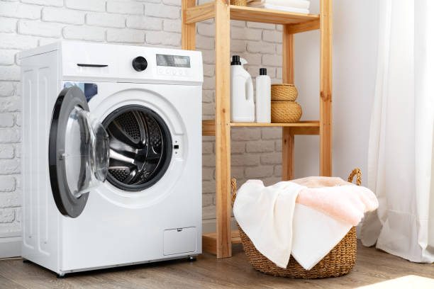 istock Laundry room with washing machine and basket with laundry 1694084078