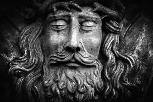 Close up fragment of antique statue of Jesus Christ as a symbol of love, faith and religion. Black and white image.