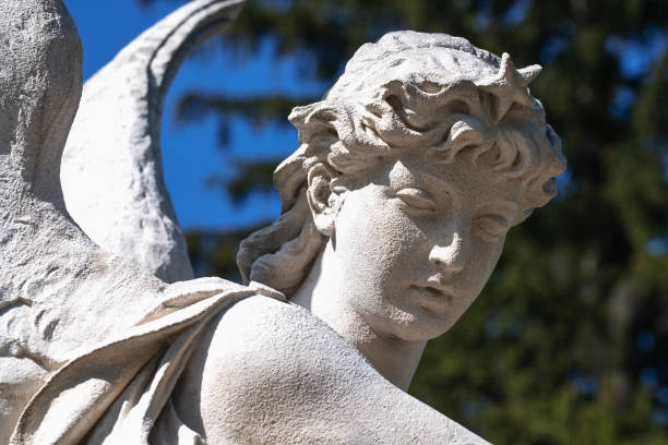 istock Angel with wings against blue sky. Ancient statue.  Close up. 1694087419