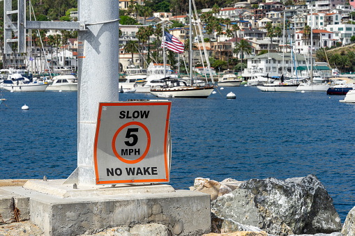 Avalon, CA, USA - September 13, 2023: Slow, 5 MPH, No Wake posted sign at the Avalon Harbor at Catalina Island in California.