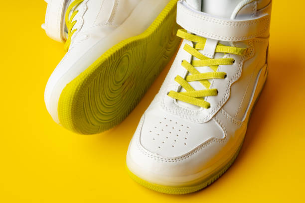 istock White sneakers with yellow neon laces on yellow background 1694097515
