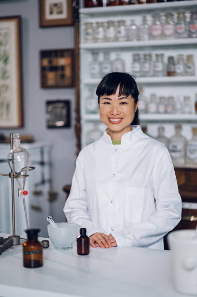 istock Japanese pharmacist standing in a vintage apothecary while making a cure 1694103173