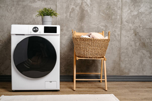 istock Laundry room interior with washing machine near gray grunge wall 1694124178