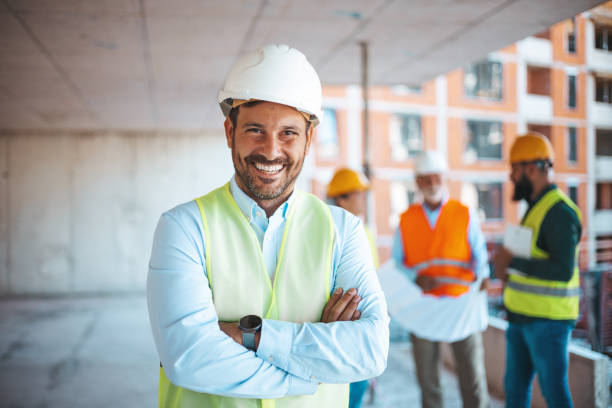 istock Portrait of man architect at building site with folded arms looking at camera. 1694129971