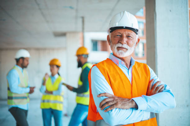 istock Portrait of confident elderly construction engineer in classic suit and hardhat 1694130829