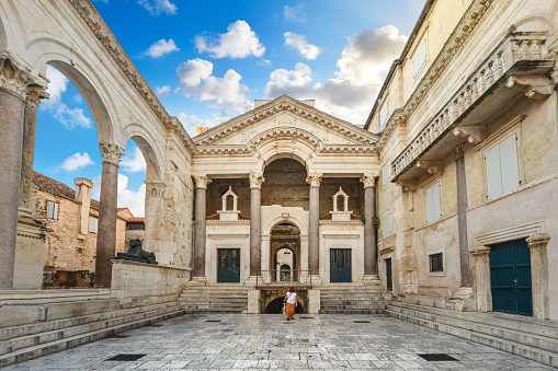 A woman walks through the Peristil or Peristyle Square of the ancient Diocletian's Palace in the old town area of Split, Croatia early in the morning.