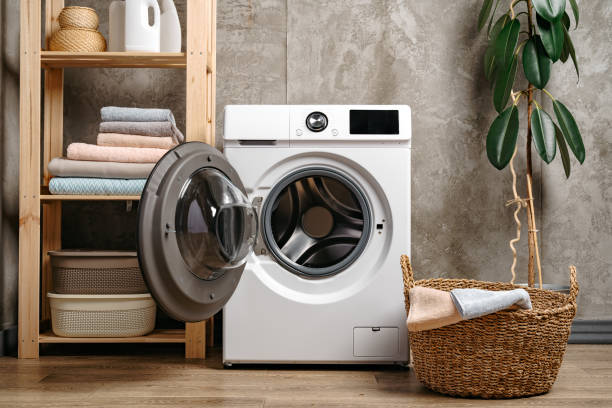istock Laundry room interior with washing machine near gray grunge wall 1694137615