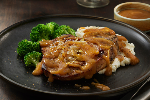 Grilled Bone In Pork Chop with Mashed Potatoes, Broccoli, Fried Onions and Gravy